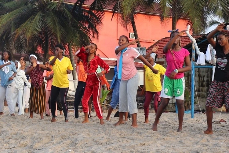 A group dancing together on the beach.